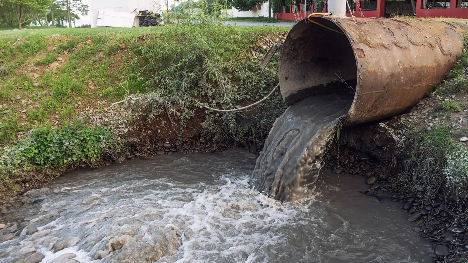 Sewage and Wastewater Bypass Large culvert pipe discharging wastewater into an open channel